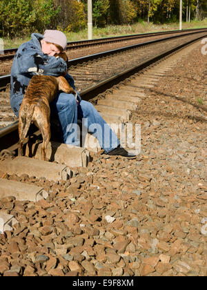 Une femme avec un chien sur le chemin de fer Banque D'Images