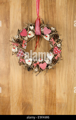 Couronne de noël décoré en rouge et blanc oreiller coeur brown brindilles vichy et pois sur fond de bois sapele, copier sp Banque D'Images