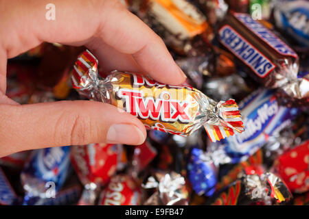 Paphos, Chypre - 19 décembre 2013 Twix candy dans woman's hand avec arrière-plan de Snickers, Mars, Twix, Milky Way, Galaxy, Bounty Banque D'Images