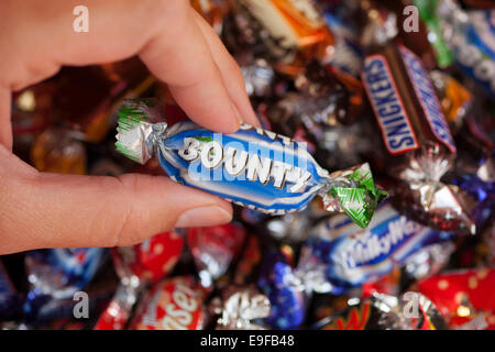 Paphos, Chypre - Décembre 19, 2013 Woman's hand holding Bounty candy contre fond de bonbons fabriqués par Mars. Banque D'Images