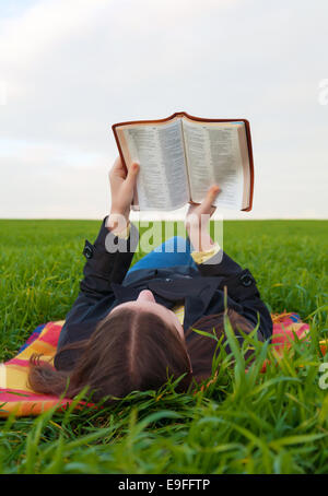 Teen girl lire la Bible à l'extérieur Banque D'Images