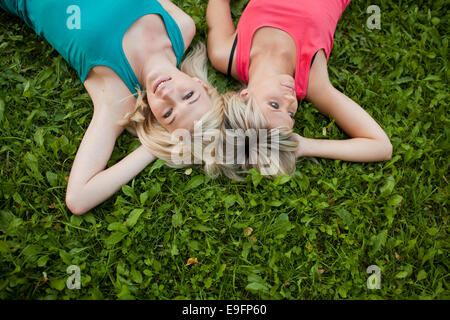 Deux jeunes filles se trouvent ensemble sur l'herbe et profiter Banque D'Images