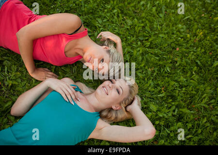 Deux jeunes filles se trouvent ensemble sur l'herbe et profiter Banque D'Images