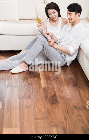 Cheerful young couple using a digital tablet shopping online Banque D'Images