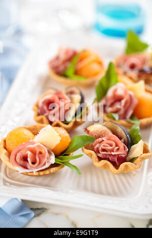 Tartelettes à la viande, basilic, boules de melon et de figue. Banque D'Images