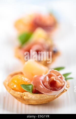 Tartelettes à la viande, basilic, boules de melon et de figue. Banque D'Images