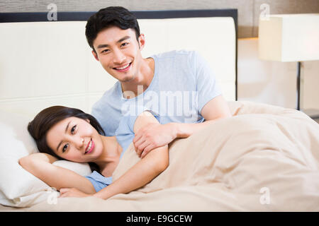 Jeune couple lying on bed Banque D'Images
