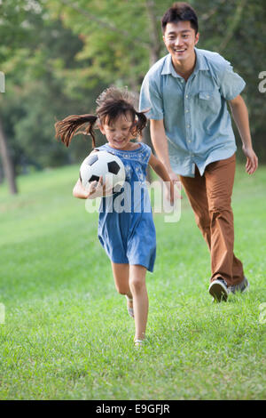 Heureux père et fille jouant au football Banque D'Images