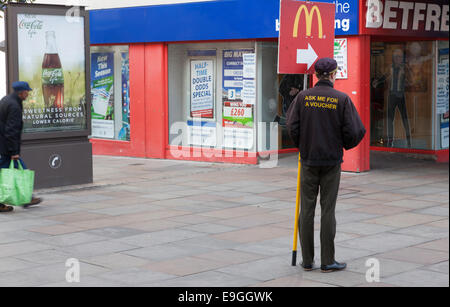 Les employés de McDonald's avec bandeau publicitaire street, Coventry, Angleterre, RU Banque D'Images