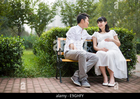 Femme enceinte et son mari assis sur un banc Banque D'Images