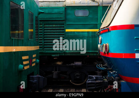 Détails des locomotives électriques tête à tête sur les rails. Jouer ou vert, rouge, jaune, bleu et blanc Banque D'Images