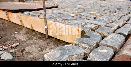 Pavage de galets traditionnels étant posés par le contacteur de construction Banque D'Images