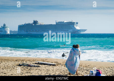 Les gens sur la plage à Cannes, France. Les bateaux de croisière sont ancrés dans l'arrière-plan. Banque D'Images