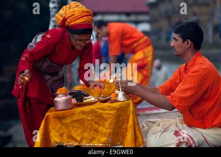 Katmandou, Népal. 27 Oct, 2014. Un saint prêtre du temple de Pashupatinath se prépare pour l'aarti (procession religieuse hindoue) à Katmandou, Népal, le 27 octobre 2014. Chaque matin et soir Aarti est fait pour rendre hommage à dieu hindou Shiva. Credit : Pratap Thapa/Xinhua/Alamy Live News Banque D'Images