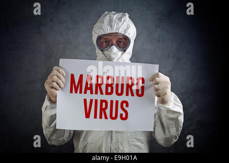 Soins de santé médicaux worker wearing gown de protection, gants, masque et lunettes et holding paper avec titre Virus de Marburg. Banque D'Images