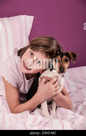 Fille au lit avec un Suédois Farmdog danois Banque D'Images