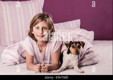 Fille au lit avec un Suédois Farmdog danois Banque D'Images