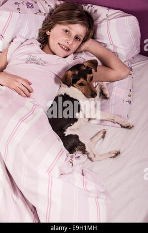 Fille au lit avec un Suédois Farmdog danois Banque D'Images