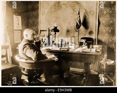Photographie de l'explorateur norvégien Roald Amundsen dans son bureau à Uranienborg, prise en 1910 par Anders Beer Wilse. Amundsen est représenté dans son espace de travail, reflétant son accent sur l'exploration et les expéditions polaires. Banque D'Images