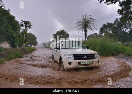 Conduite de voiture sur une rue inondée pendant la saison des pluies, près de Makeni, District de Bombali, Sierra Leone Banque D'Images