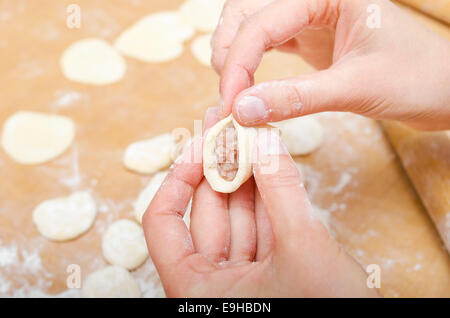 Mains d'une femme qui boulettes sur table de cuisine moules Banque D'Images