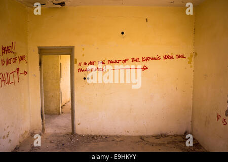 Graffiti sur des bâtiments militaires abandonnés près de la mer morte, Israël, montrant de la peinture écaillée, de l'art mural et des structures désertiques abandonnées Banque D'Images