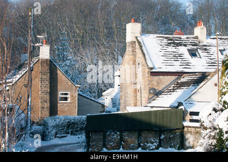 Scènes hivernales de Robin Hood’s Bay, dans le Yorkshire du Nord, avec des chalets enneigés, des vues à flanc de colline et une architecture traditionnelle de village côtier Banque D'Images