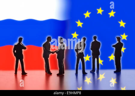 Chiffres modèle symbolisant les hommes politiques sont confrontés avec les drapeaux de la Russie et l'UE. Deux d'entre eux se serrent la main. Digital Composite (DC) Banque D'Images