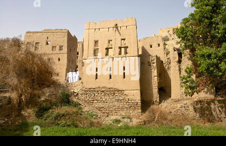 Trois jeunes hommes en costume traditionnel Omanais aux ruines de Birkat Al Mouz dans la région de Nizwa le Sultanat d'Oman. Banque D'Images