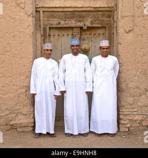 Trois jeunes hommes en costume traditionnel Omanais aux ruines de Birkat Al Mouz dans la région de Nizwa le Sultanat d'Oman. Banque D'Images