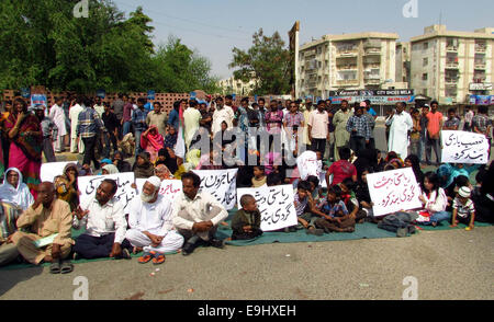 Les résidents de North Karachi protestent contre les Rangers et la police qui a détenu leurs proches au cours de l'opération de recherche tenir après l'attaque de fourgon de police qu'ils exigent la libération de personnes arrêtées lundi soir, à la maison d'alimentation Chowrangi à Karachi Mardi, Octobre 28, 2014. Banque D'Images