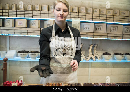 Une femme travaillant dans un chocolatier français à Paris détient la main pour voir de leurs chocolats Banque D'Images