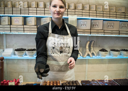 Une femme travaillant dans un chocolatier français à Paris détient la main pour voir de leurs chocolats Banque D'Images