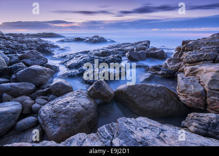 Avant l'aube, photo de Misty vagues se brisant sur les rochers de la côte sud en Afrique du Sud Banque D'Images