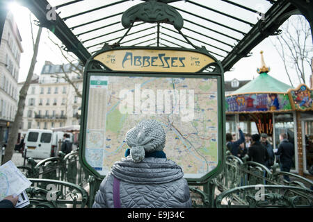 Une femme dans un lit la carte train hat en dehors d'une station de métro de Paris Banque D'Images