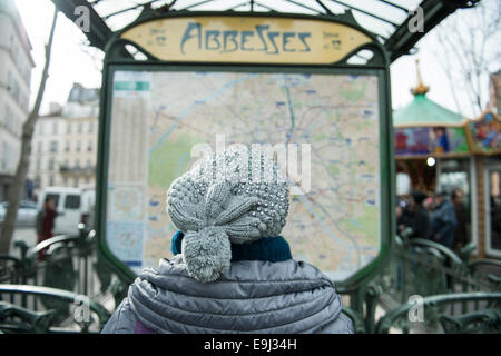 Une femme dans un lit la carte train hat en dehors d'une station de métro de Paris Banque D'Images
