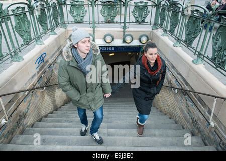 Les touristes et les banlieusards quitter un paris métro gare en hiver avec de grands manteaux sur dus au froid Banque D'Images