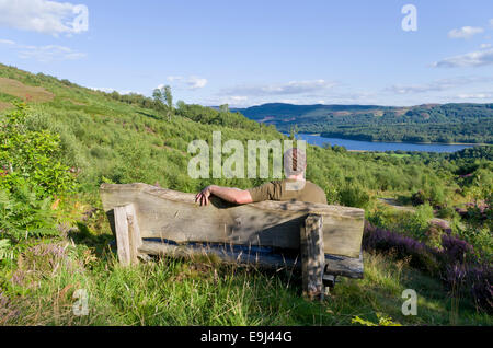 Caucasian Man sitting on a Bench à Lendrick Hill, Glen Finglas, Trossachs, Stirlingshire, Scotland, UK PUBLIÉ MODÈLE Banque D'Images