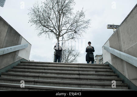 Deux touristes dans les rues de Paris en regardant une carte et prendre une photo Banque D'Images