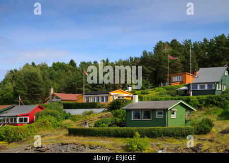 La petite île norvégienne de Lindøya au loin à l'horizon avec ses maisons colorées Banque D'Images