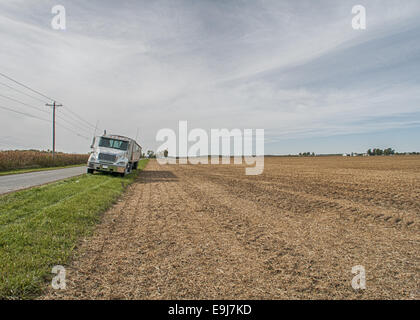 Tracteur semi remorque en attente sur le côté de la route pour recevoir une charge de soja d'une moissonneuse-batteuse. Banque D'Images