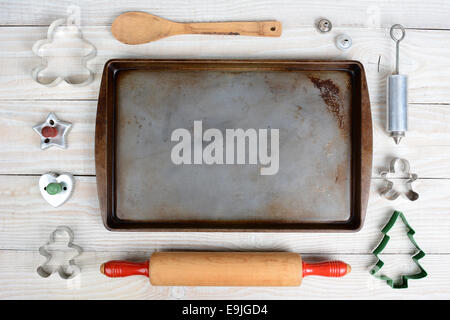 Passage tiré d'un groupe d'articles pour la cuisson des biscuits de Noël autour d'une feuille de biscuit vide. Format horizontal sur un cadre rustique Banque D'Images
