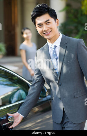 Jeune homme d'ouverture de porte de voiture Banque D'Images