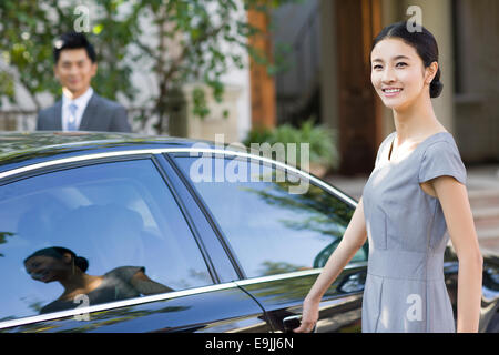 Jeune femme porte de la voiture d'ouverture Banque D'Images