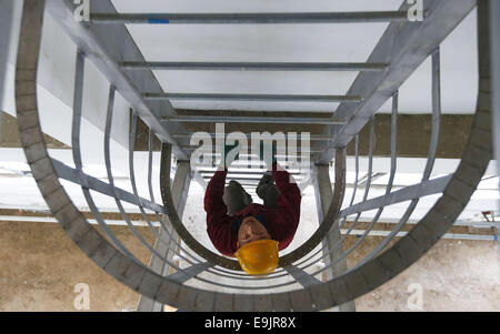 (141029) -- BEIJING, 29 octobre 2014 (Xinhua) -- un travailleur grimpe une échelle la position à l'accélération de la clarification de l étang à Guogongzhuang l'usine d'eau à Beijing, capitale de Chine, le 24 octobre 2014. L'usine d'eau Guogongzhuang a passé un test de fonctionnement et est capable de purifier l'eau qui seront transférées à Beijing par le sud/nord. L'usine, situé dans le sud de Beijing, est la première grande usine de l'eau construit par la ville dans le centre-ville pour le projet depuis 2000. Il est prévu pour fournir 500 000 mètres cubes d'eau par jour pour répondre à la demande de près de cinq millions de resid Banque D'Images