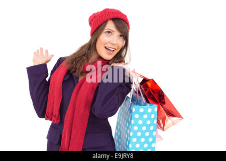 Happy brunette in winter clothes holding shopping bags Banque D'Images