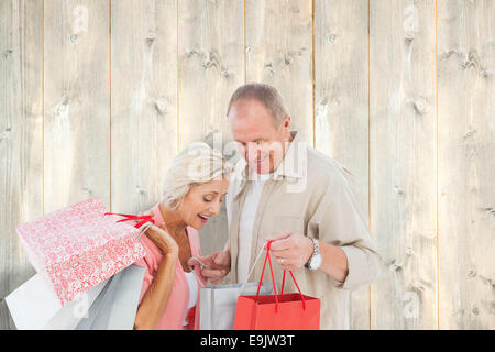 Image composite du couple with shopping bags Banque D'Images