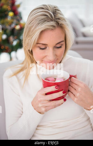 Blonde avoir du chocolat chaud sur la table à Noël Banque D'Images