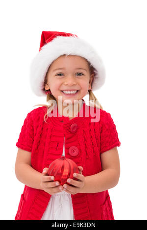 Cute little girl wearing santa hat holding bauble Banque D'Images