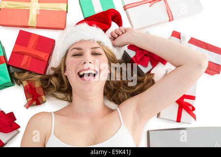 Femme souriante portant sur le plancher avec des cadeaux autour d'elle Banque D'Images